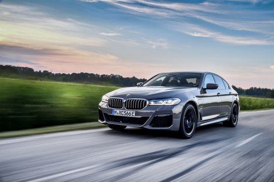 bmw 545e fährt auf einer straße my2021