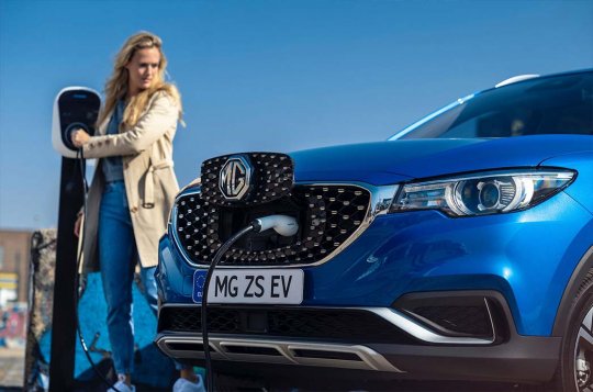 Eine Frau ladet Ihr Elektroauto