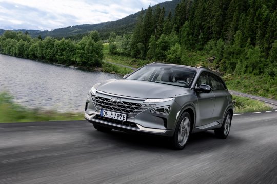 hyundai nexo fährt auf einer landstraße vor einem see