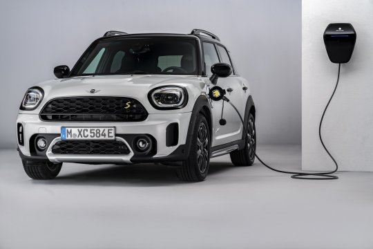 mini cooper se countryman all4 ladet an einer wallbox vor weißen hintergrund